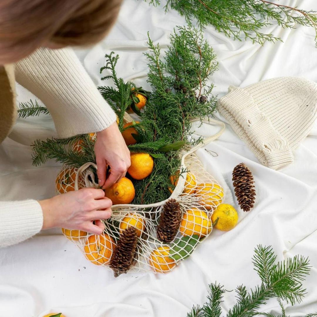 Авоська с мандаринами и ветками хвои